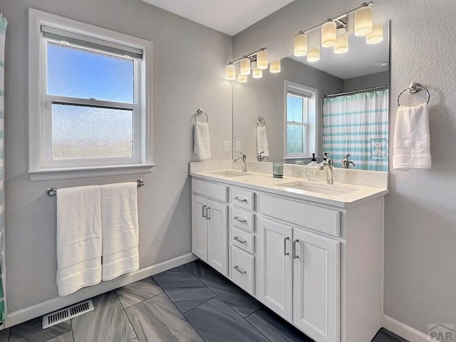 439 N Mitford Dr, Pueblo West, CO 81007 - bathroom with double vanity, baseboards, and a shower with curtain