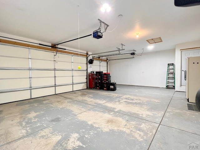 439 N Mitford Dr, Pueblo West, CO 81007 - garage with a garage door opener and freestanding refrigerator