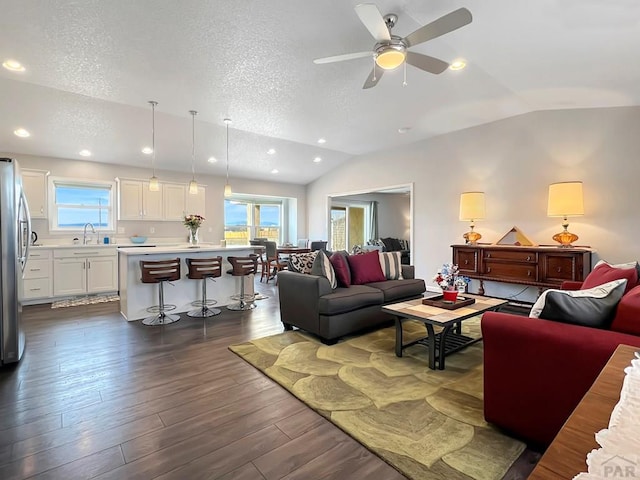439 N Mitford Dr, Pueblo West, CO 81007 - living room featuring vaulted ceiling, a textured ceiling, dark wood-style flooring, ceiling fan, and recessed lighting