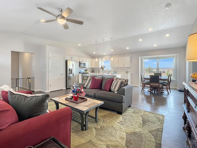 439 N Mitford Dr, Pueblo West, CO 81007 - living room with vaulted ceiling, wood finished floors, a ceiling fan, a textured ceiling, and baseboards