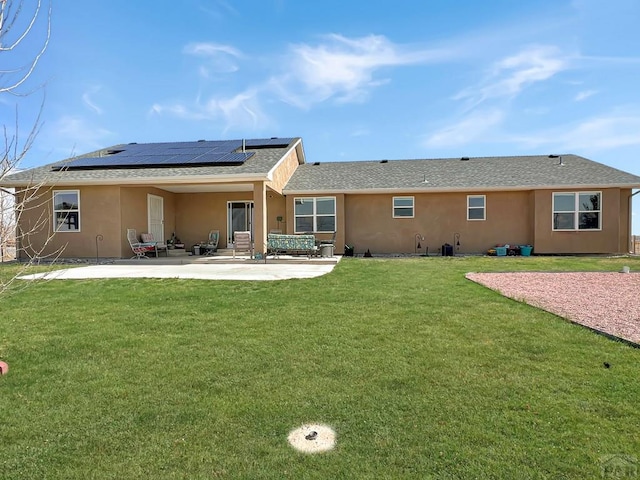 439 N Mitford Dr, Pueblo West, CO 81007 - back of property with stucco siding, roof mounted solar panels, a patio, and a yard