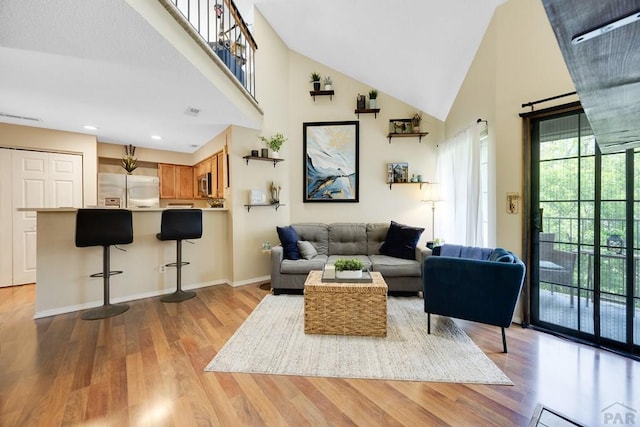 830 S Vance St, Lakewood, CO 80226 - living area with high vaulted ceiling, wood finished floors, baseboards, and recessed lighting