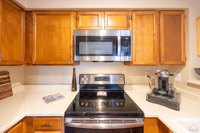 830 S Vance St, Lakewood, CO 80226 - kitchen featuring appliances with stainless steel finishes, light countertops, and brown cabinets