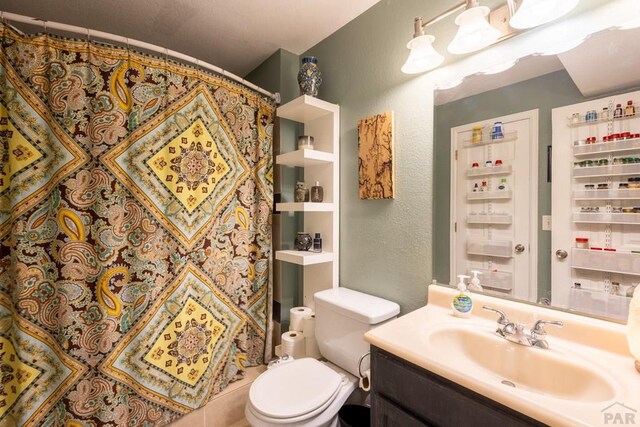 830 S Vance St, Lakewood, CO 80226 - full bathroom featuring a textured wall, vanity, toilet, and a shower with shower curtain