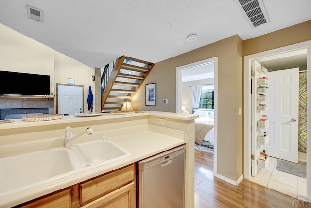 830 S Vance St, Lakewood, CO 80226 - kitchen featuring open floor plan, stainless steel dishwasher, a sink, and light wood-type flooring