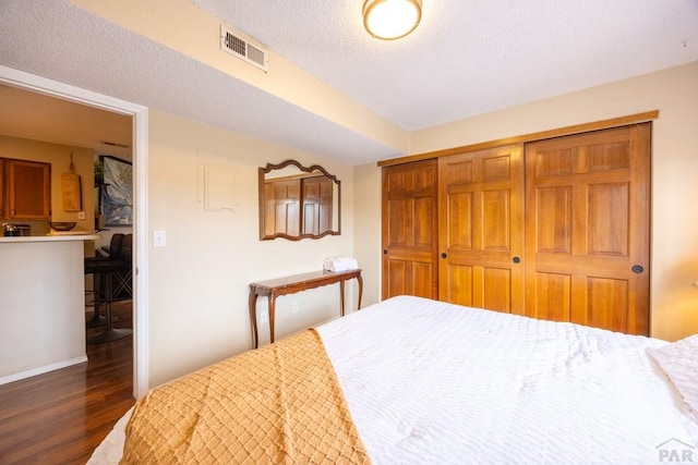 830 S Vance St, Lakewood, CO 80226 - bedroom with wood finished floors, a closet, baseboards, and a textured ceiling