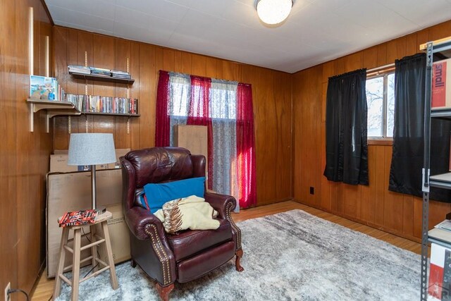 living area featuring wood walls and light wood-style flooring