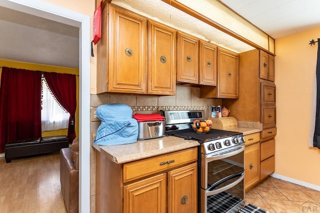 kitchen featuring brown cabinets, double oven range, and light countertops