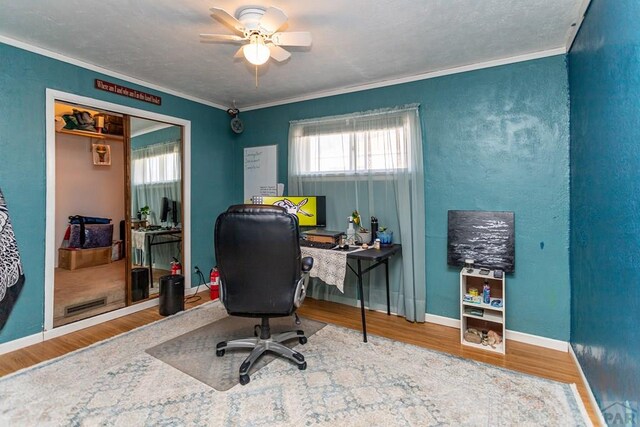 office area featuring ceiling fan, crown molding, baseboards, and wood finished floors