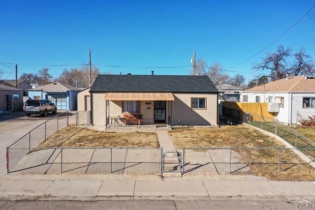 bungalow featuring concrete driveway, a fenced front yard, a residential view, a porch, and stucco siding