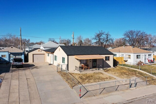 view of front of property featuring driveway, a fenced front yard, a residential view, a porch, and stucco siding