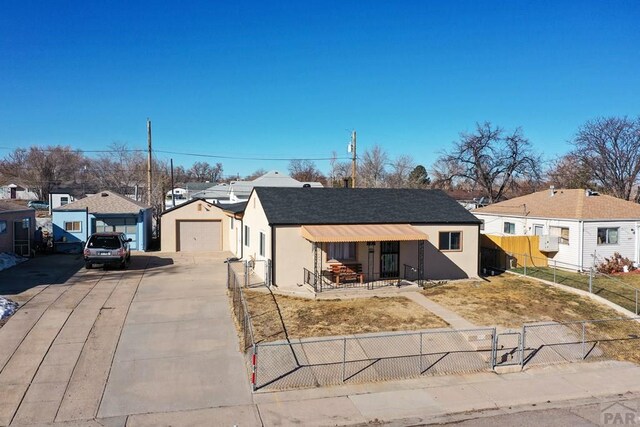 view of front of property featuring driveway, fence private yard, a residential view, and stucco siding