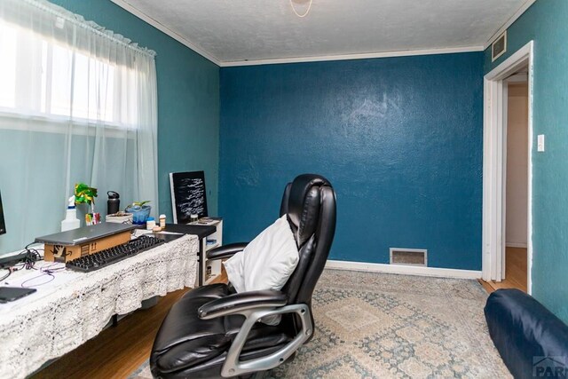 office area with baseboards, visible vents, and ornamental molding