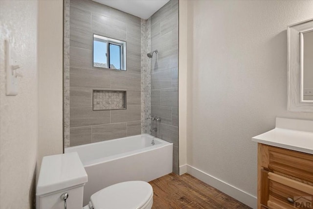 full bath featuring toilet, baseboards, wood finished floors, washtub / shower combination, and vanity