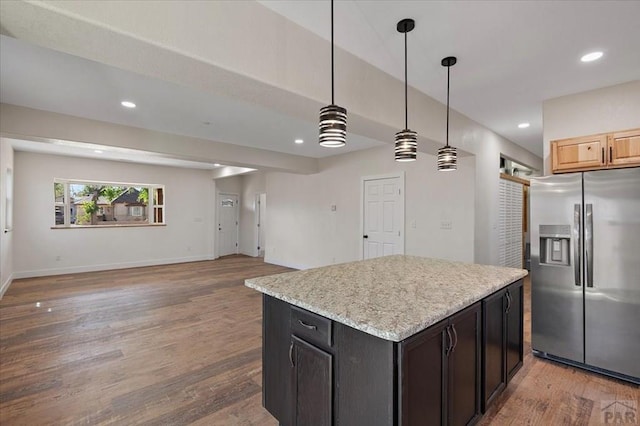 kitchen featuring recessed lighting, open floor plan, wood finished floors, and stainless steel fridge