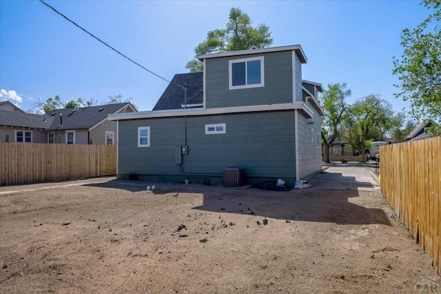 rear view of property with cooling unit and a fenced backyard