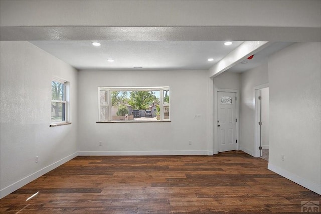 unfurnished room featuring baseboards, wood finished floors, and recessed lighting