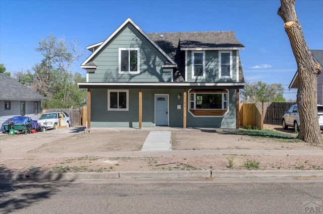 view of front of home featuring covered porch and fence