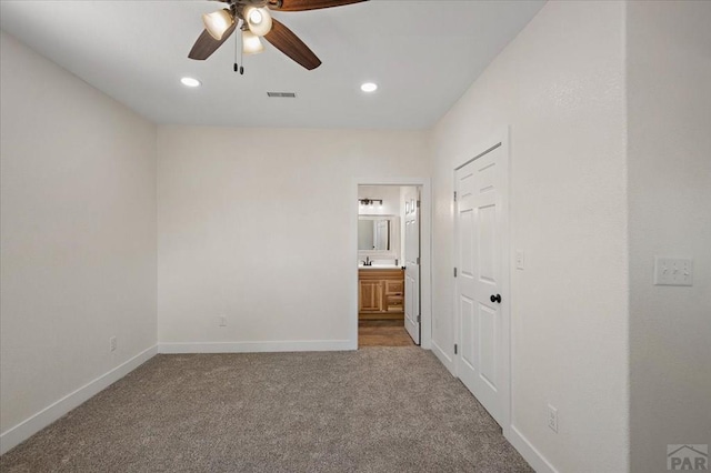 unfurnished bedroom with carpet, visible vents, baseboards, and ensuite bathroom