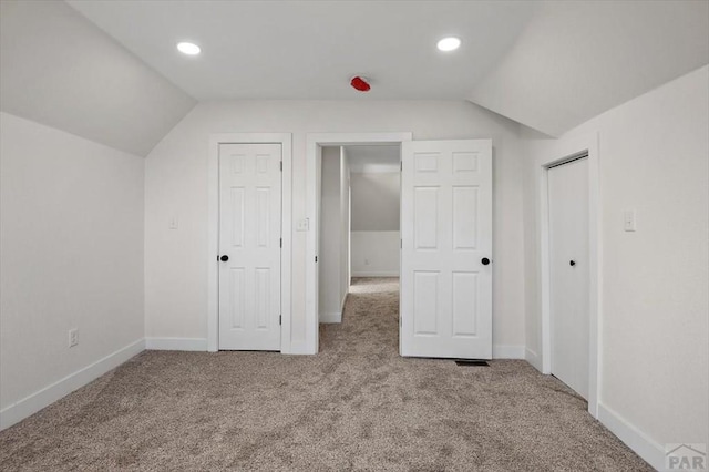 additional living space featuring carpet floors, vaulted ceiling, and baseboards