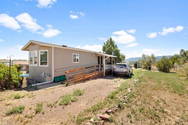 back of property with driveway and a lawn