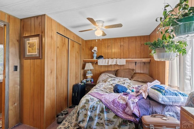 bedroom featuring wood walls, a closet, and a ceiling fan