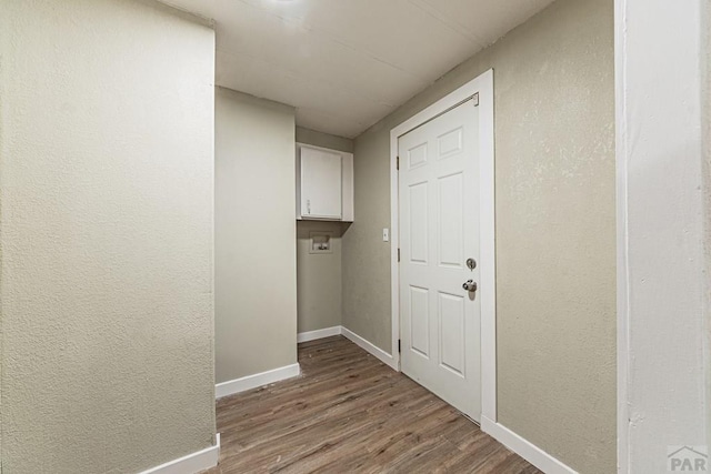 hall with baseboards and wood finished floors