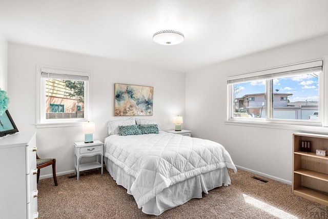 carpeted bedroom featuring multiple windows, visible vents, and baseboards