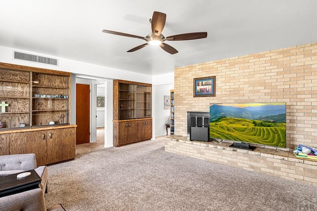 living room with ceiling fan, visible vents, carpet floors, and brick wall