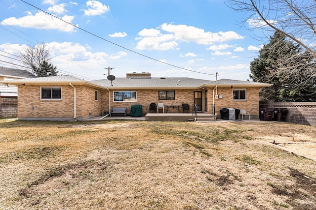 back of property with brick siding, a patio area, a yard, and fence