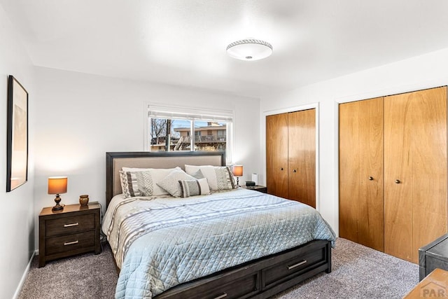 bedroom with baseboards, carpet floors, and multiple closets