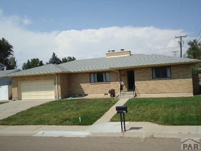 ranch-style house with brick siding, a front lawn, driveway, crawl space, and an attached garage