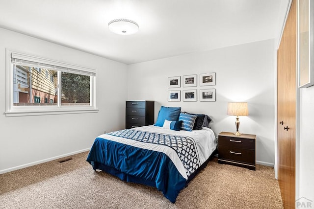 carpeted bedroom featuring visible vents and baseboards