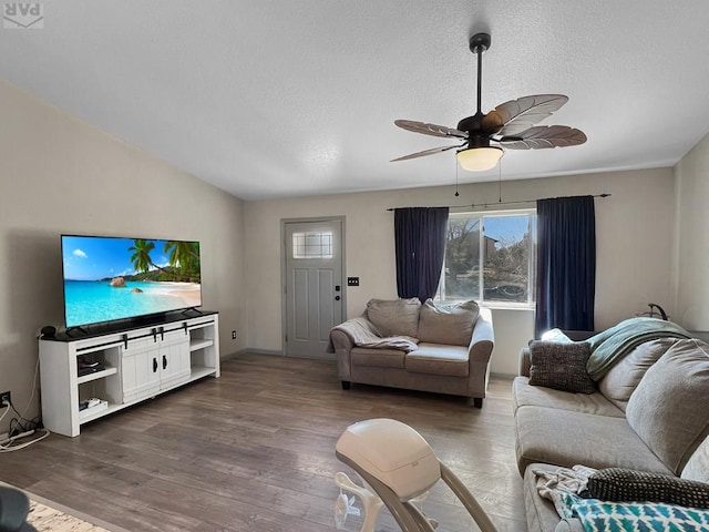 living area featuring a textured ceiling, wood finished floors, and a ceiling fan