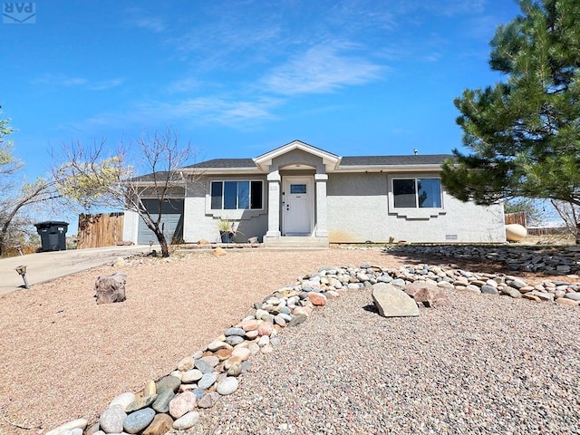 ranch-style house featuring an attached garage, driveway, and stucco siding