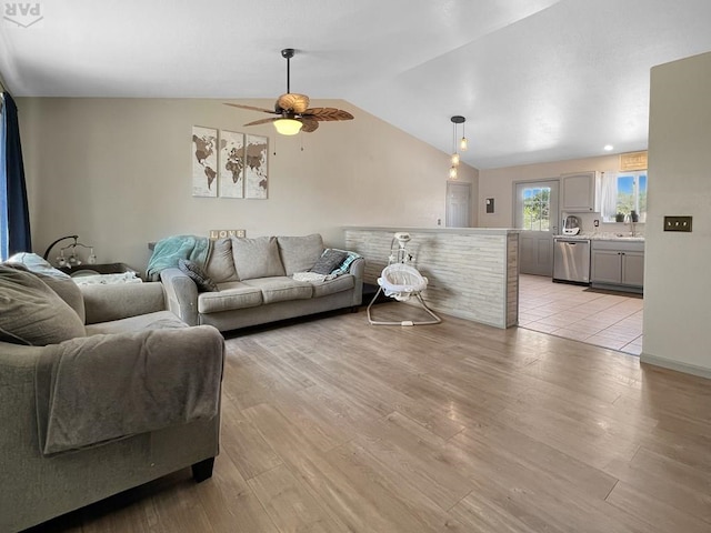 living room featuring light wood-style flooring, a ceiling fan, and vaulted ceiling
