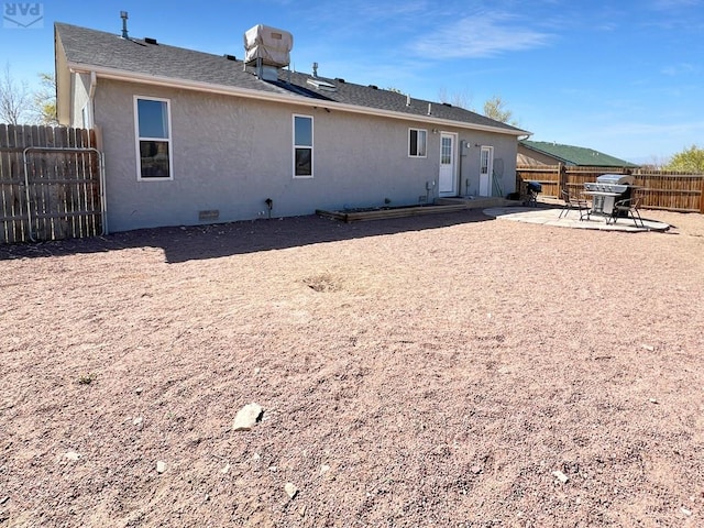 back of house featuring a patio area, fence private yard, and stucco siding