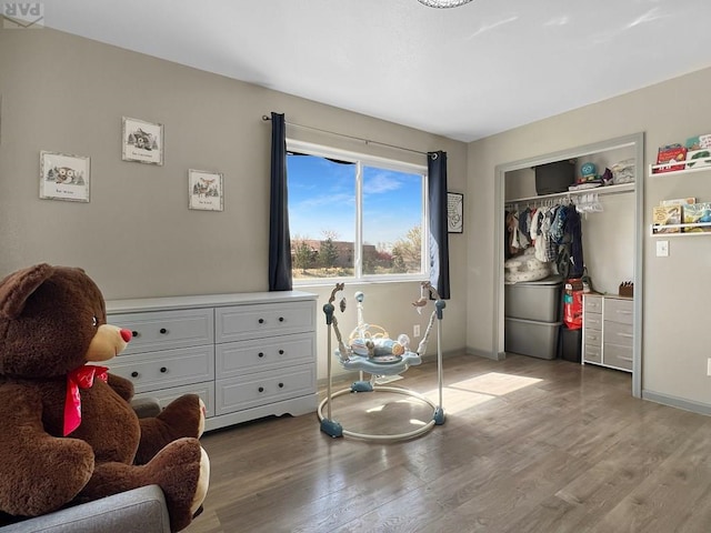 bedroom featuring a closet, baseboards, and wood finished floors