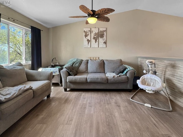 living room with wood finished floors, a ceiling fan, and vaulted ceiling