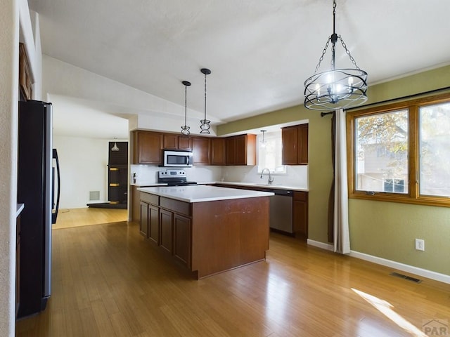 kitchen featuring visible vents, hanging light fixtures, appliances with stainless steel finishes, light countertops, and a center island