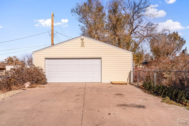 detached garage featuring fence