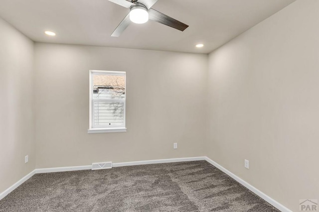 unfurnished room with carpet floors, visible vents, and baseboards