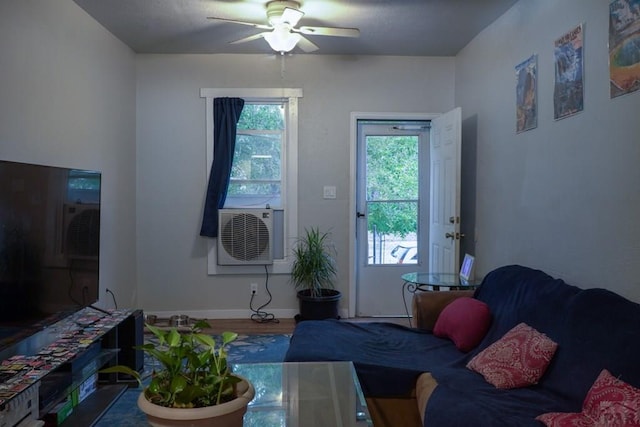 living room with wood finished floors, cooling unit, a ceiling fan, and baseboards