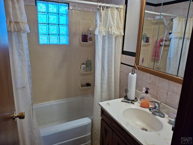 bathroom with shower / bathtub combination with curtain, tile walls, and vanity