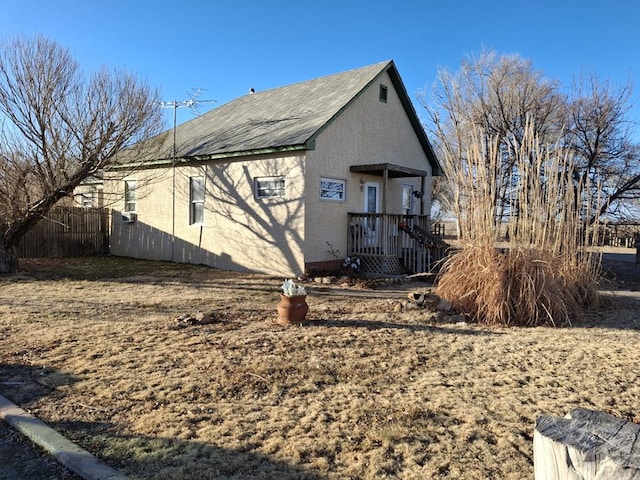 view of side of home with fence and stucco siding