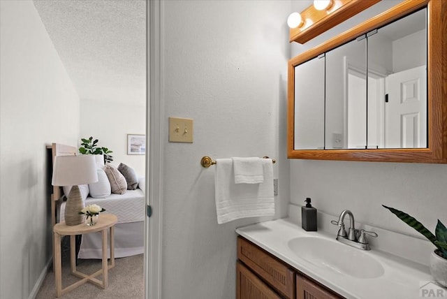 bathroom featuring ensuite bath, vanity, and a textured ceiling