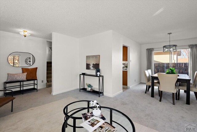 139 Princeton St, Pueblo, CO 81005 - dining room featuring light colored carpet, a textured ceiling, baseboards, and stairs