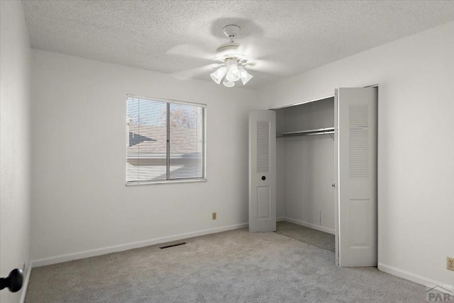 unfurnished bedroom featuring a closet, light carpet, visible vents, and baseboards