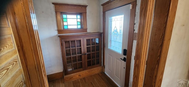 doorway with baseboards and wood finished floors