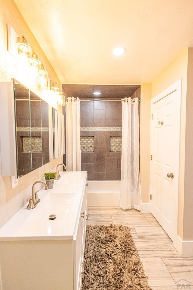 full bath with double vanity, shower / bathtub combination with curtain, baseboards, and a sink